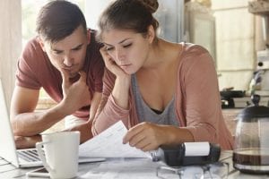 Concerned young couple looks over a stack of bills. For many people, filing for bankruptcy is a sensible option that offers almost immediate relief from harassing debt collection phone calls and a way out from under a growing mountain of debt.