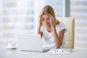 Divorced woman looking at finances on her laptop. Divorced individuals who are considering filing for bankruptcy often wonder if the bankruptcy will wipe out their marital settlement agreement.